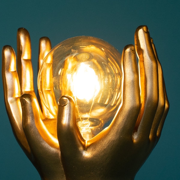 Tischleuchte Golden Touch, gold , Hände halten das Leuchtmittel Werner Voss